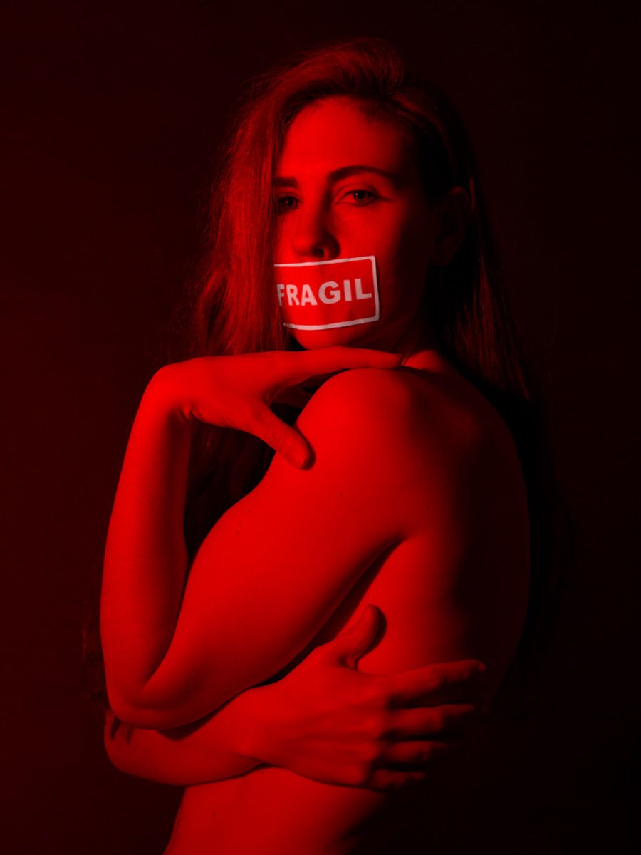 Fotografía de retrato realizada por Alba Mozas Gómez en estudio profesional en Madrid, donde una mirada frágil sobre fondo rojo forma parte de una obra de arte contemporáneo expuesta, creada por una artista mujer desde una mirada autoral.