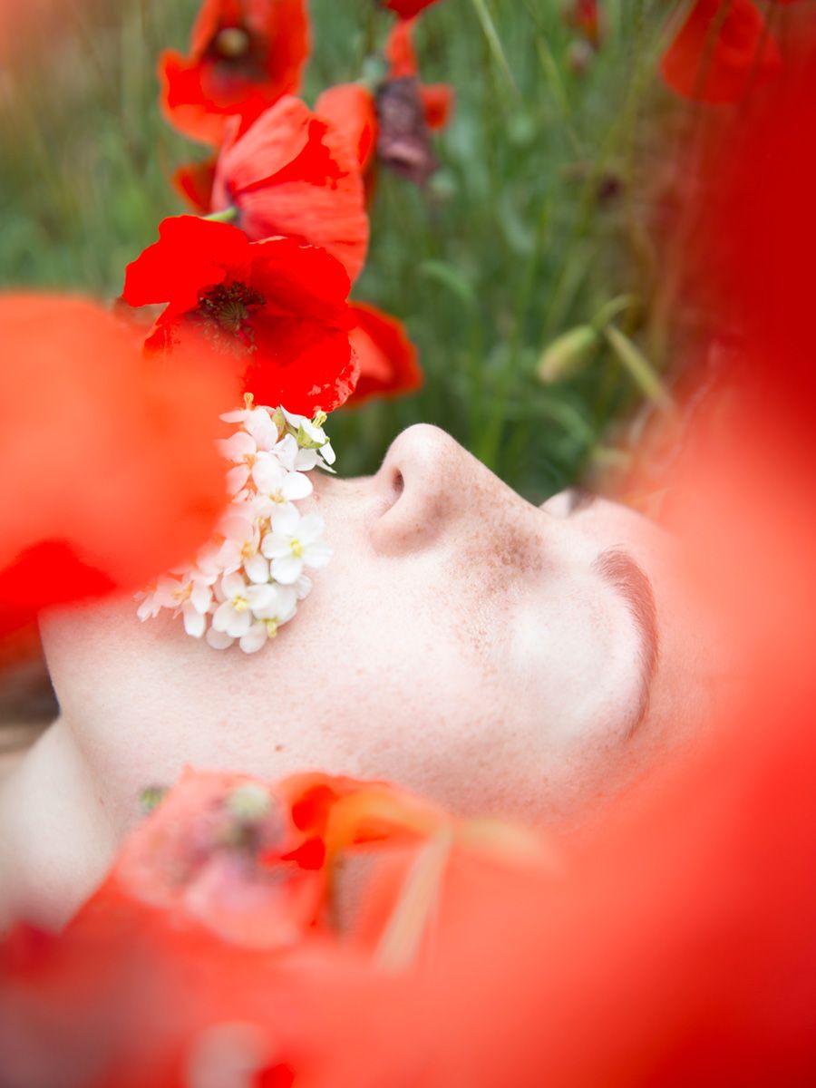 Fotografía de retrato realizada por Alba Mozas Gómez en estudio profesional en Madrid, donde una mirada frágil sobre fondo rojo forma parte de una obra de arte contemporáneo expuesta, creada por una artista mujer desde una mirada autoral.