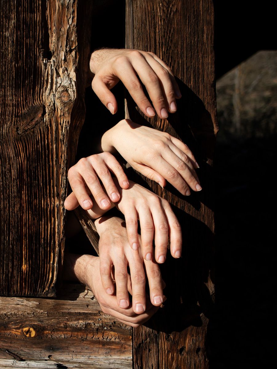 Imagen de varias manos saliendo a través de una puerta antigua en medio de la naturaleza, imagen de la fotógrafa Alba Mozas Gómez